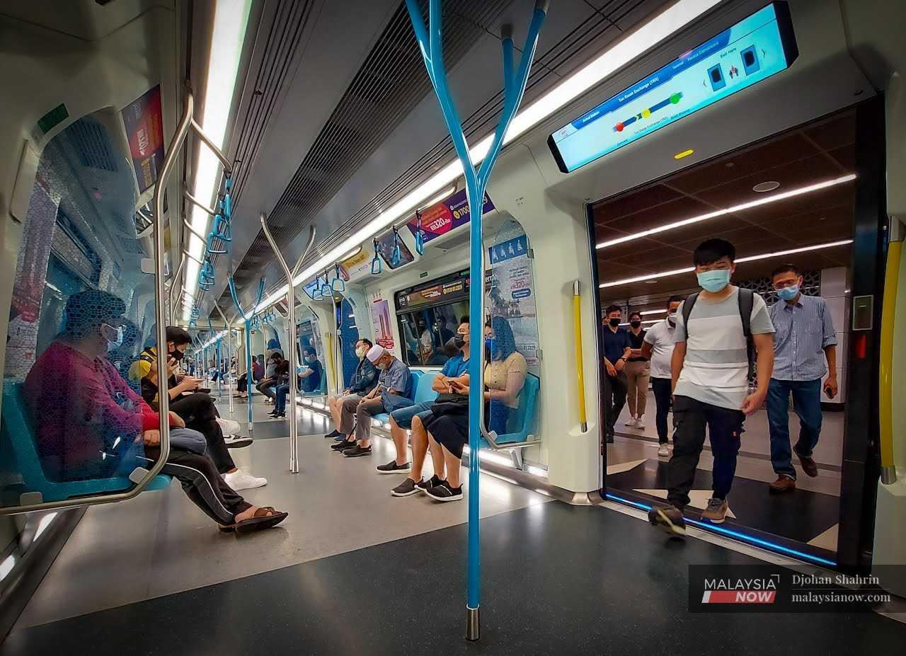 Commuters enter an MRT at the Tun Razak Exchange station in Kuala Lumpur. 