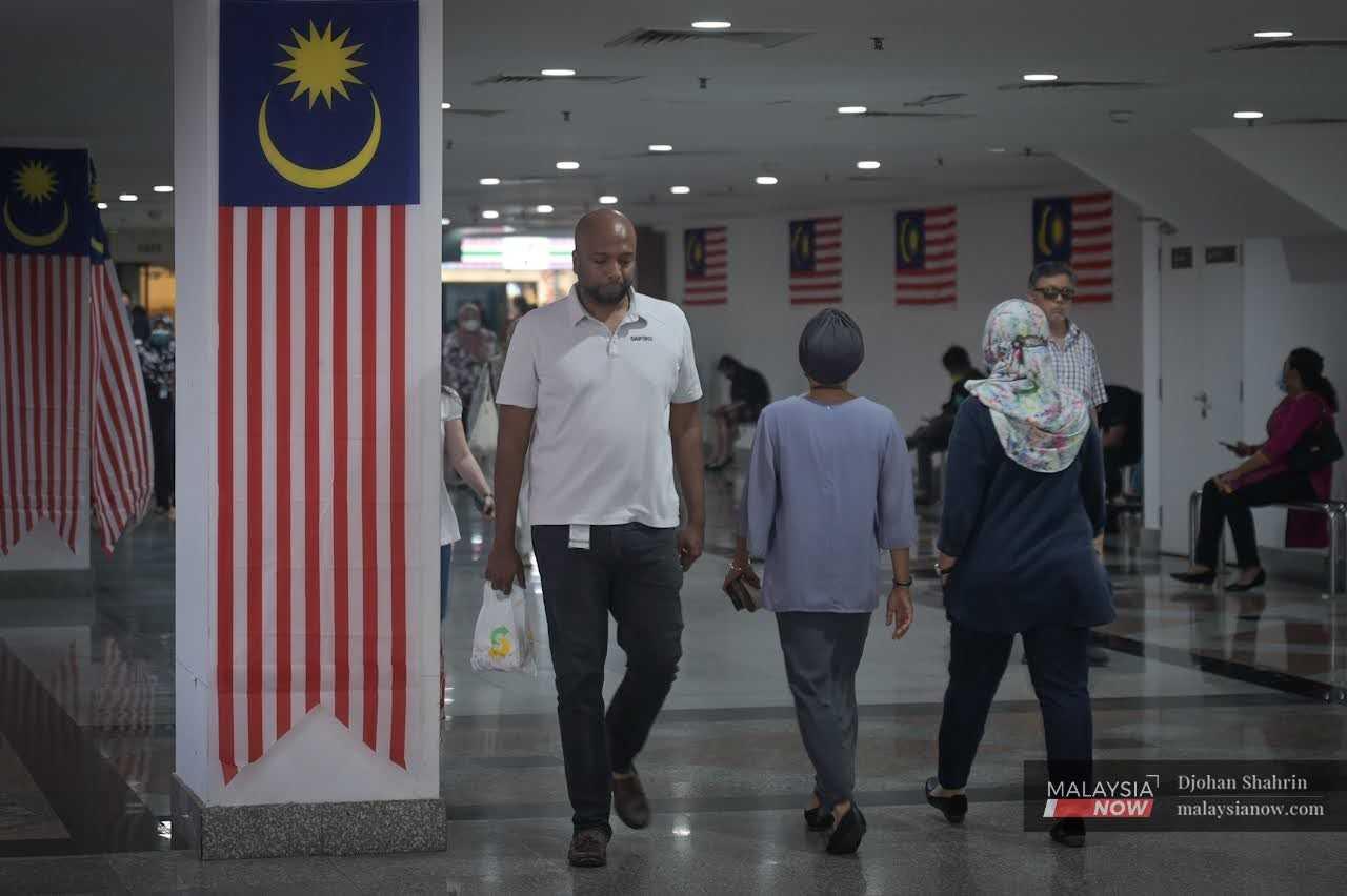 Pengunjung berjalan kaki ketika waktu rehat makan tengah hari di KL Sentral, Kuala Lumpur. 