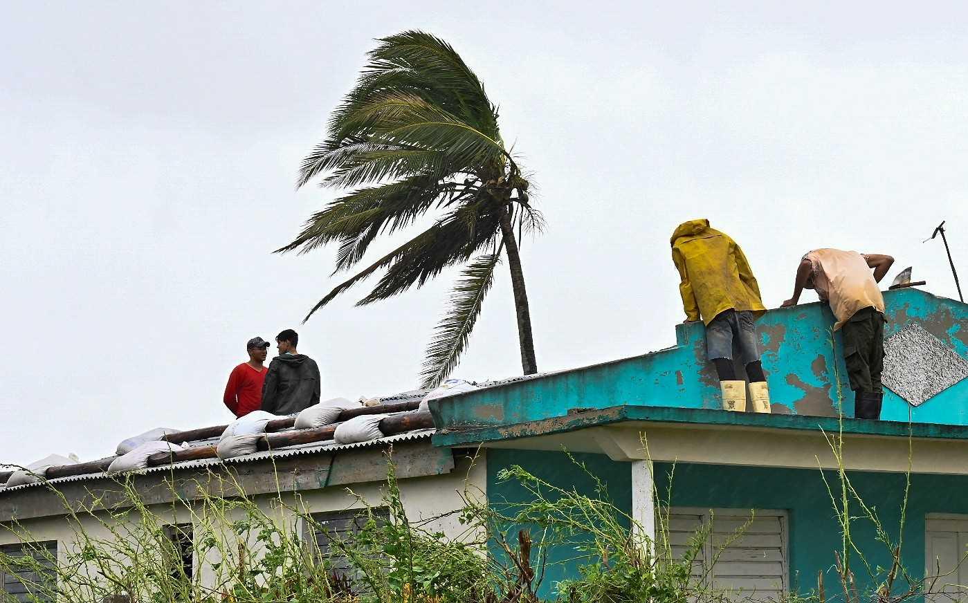 Cubans repair a roof in San Juan y Martinez, Pinar del Rio Province, on Sept 27, after the passage of Hurricane Ian. Photo: AFP