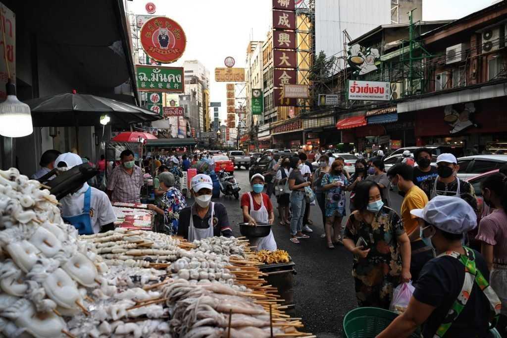 In this photo taken on Jan 16, people queue up for grilled seafood sticks in the Chinatown area of Bangkok. Photo: AFP
