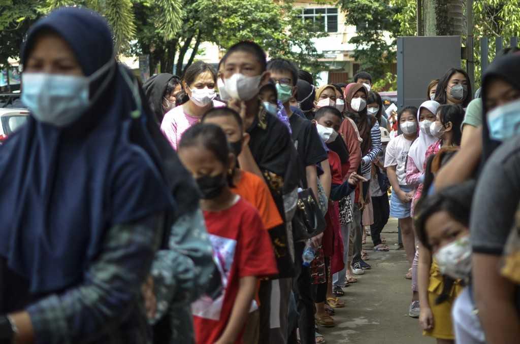 Parents accompany their children to be vaccinated against Covid-19 in Palembang, South Sumatra on Jan 9, 2021. Photo: AFP