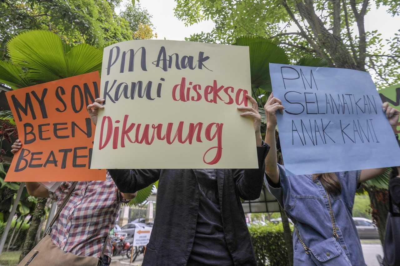 Representatives from NGOs hold up signs at a gathering in Putrajaya calling for the government's intervention in the matter of job scams in other countries involving Malaysians. Photo: Bernama
