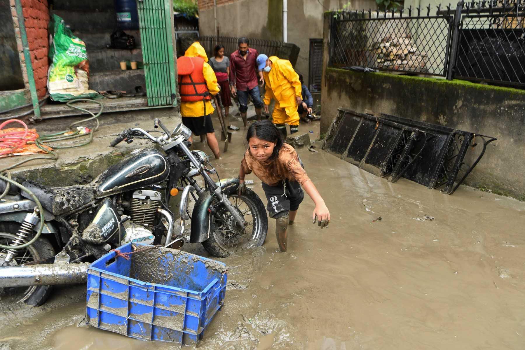 A girl walks through a street which was flooded after Bishnumati river overflowed following heavy monsoon rains in Kathmandu on Sept 6, 2021. Photo: AFP 