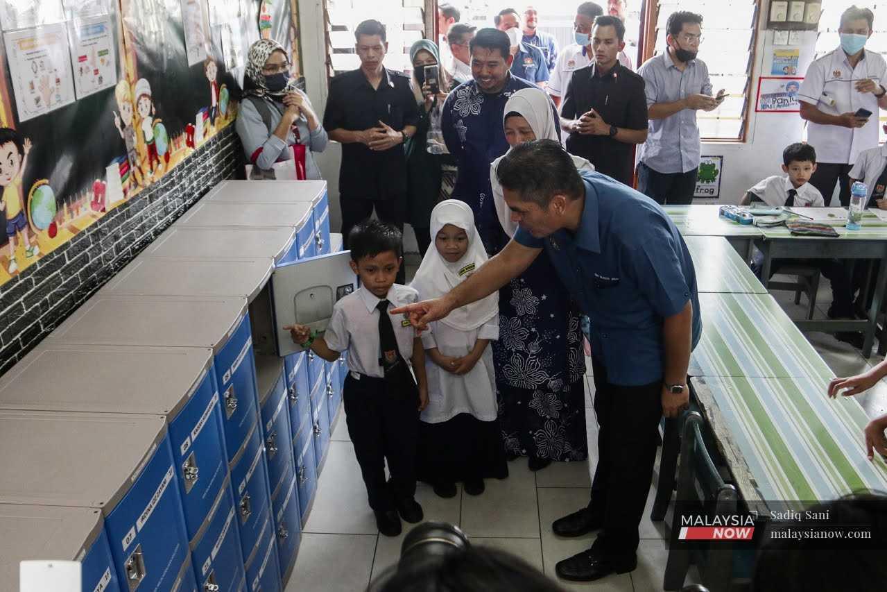 Menteri Pendidikan Radzi Jidin berbual dengan murid Sekolah Kebangsan Gombak Setia ketika acara pelancaran pemasangan lokar fasa pertama hari ini.