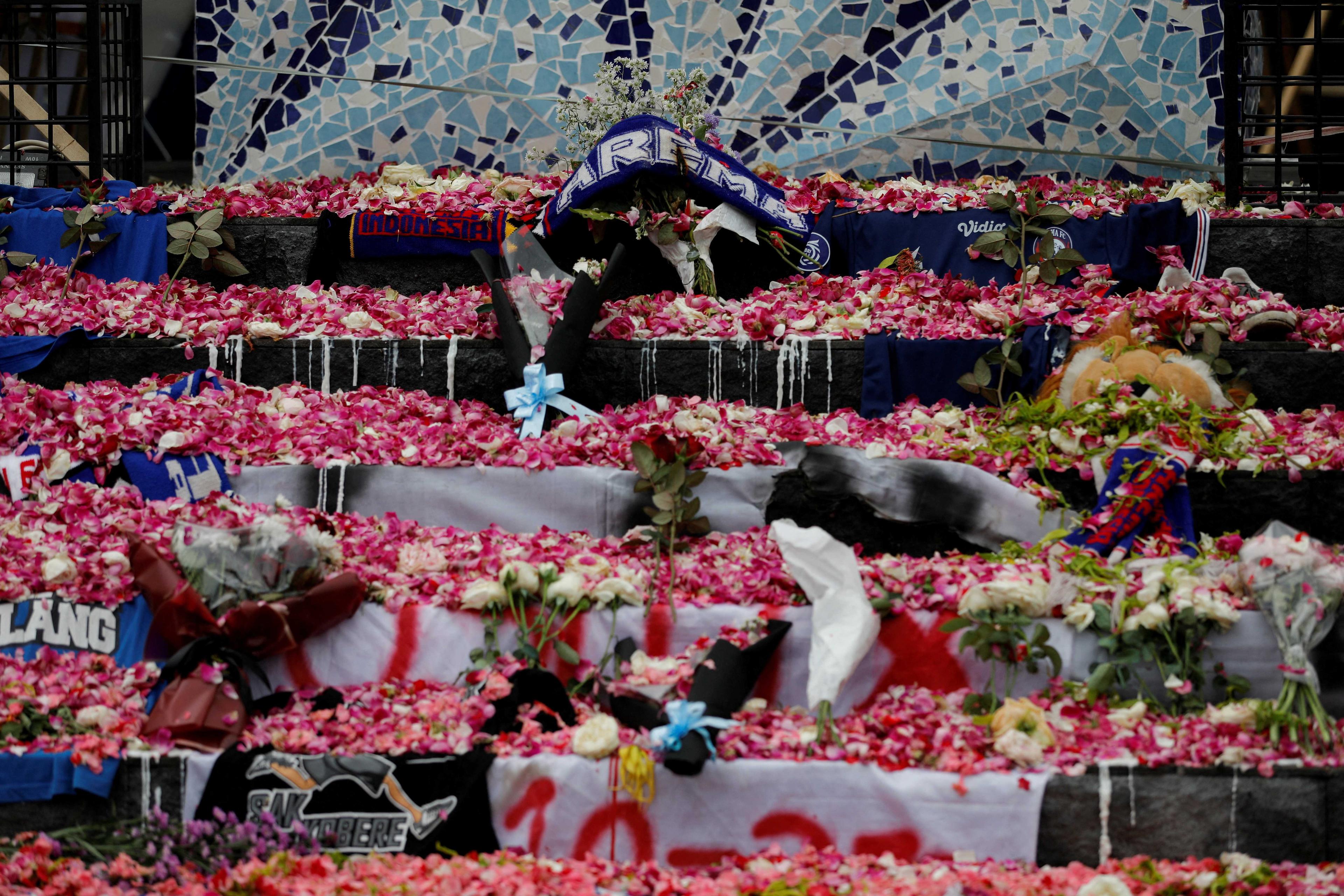 Petals and Arema FC supporters' tributes are placed on a monument to pay condolence to the victims of a riot and stampede following a football match between Arema FC and Persebaya Surabaya teams, outside the Kanjuruhan Stadium, in Malang, East Java province, Indonesia, Oct 3. Photo: Reuters