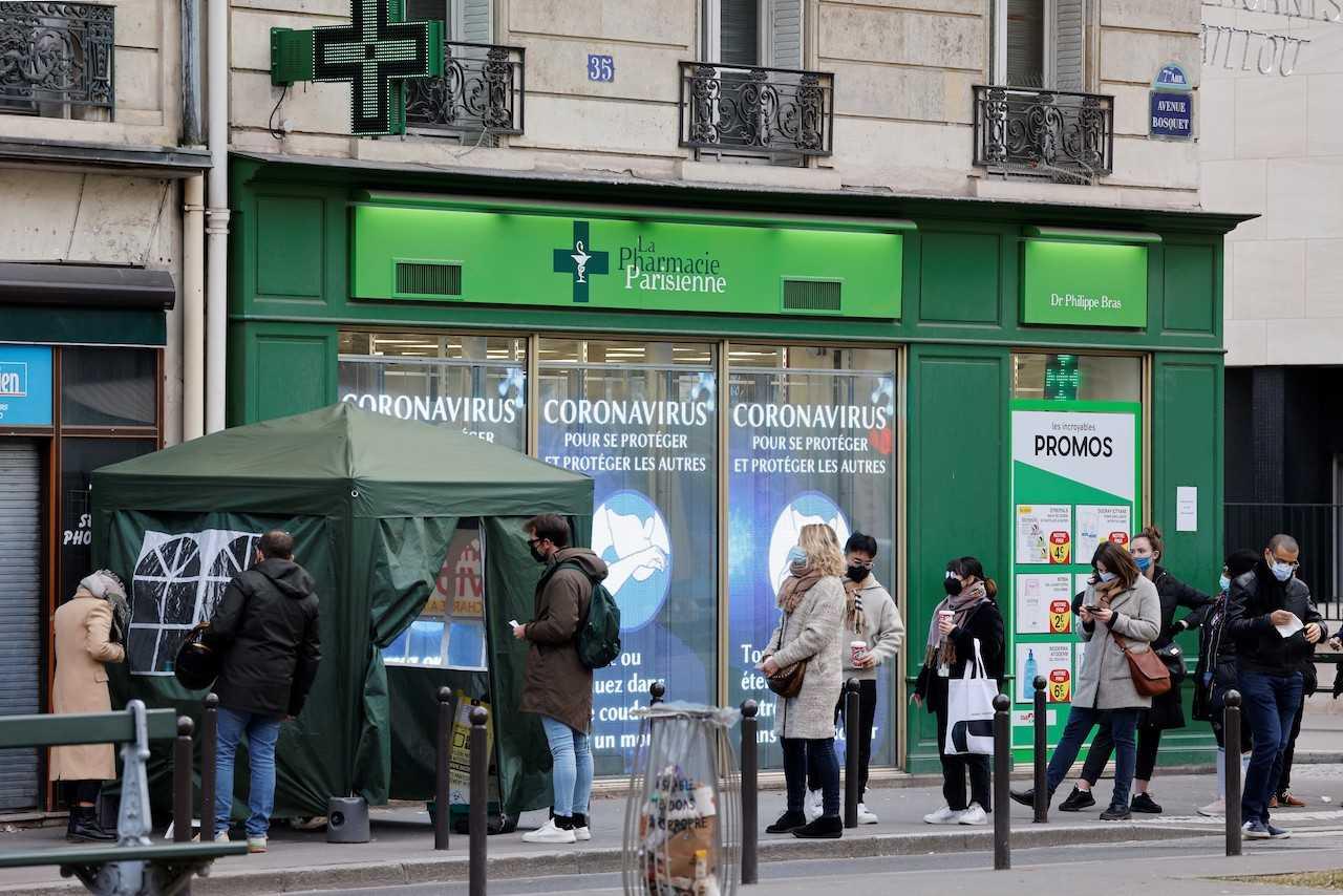 Members of the public queue outside a pharmacy to receive Covid-19 antigen tests in Paris on Jan 6. Photo: AFP