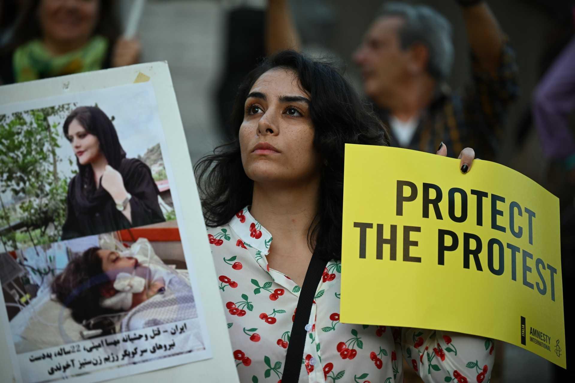 A protester holds pictures of Kurdish Iranian woman Mahsa Amini during a demonstration in Piazza del Campidoglio in Rome on Oct 5, following her death in the custody of morality police in Iran. Photo: AFP