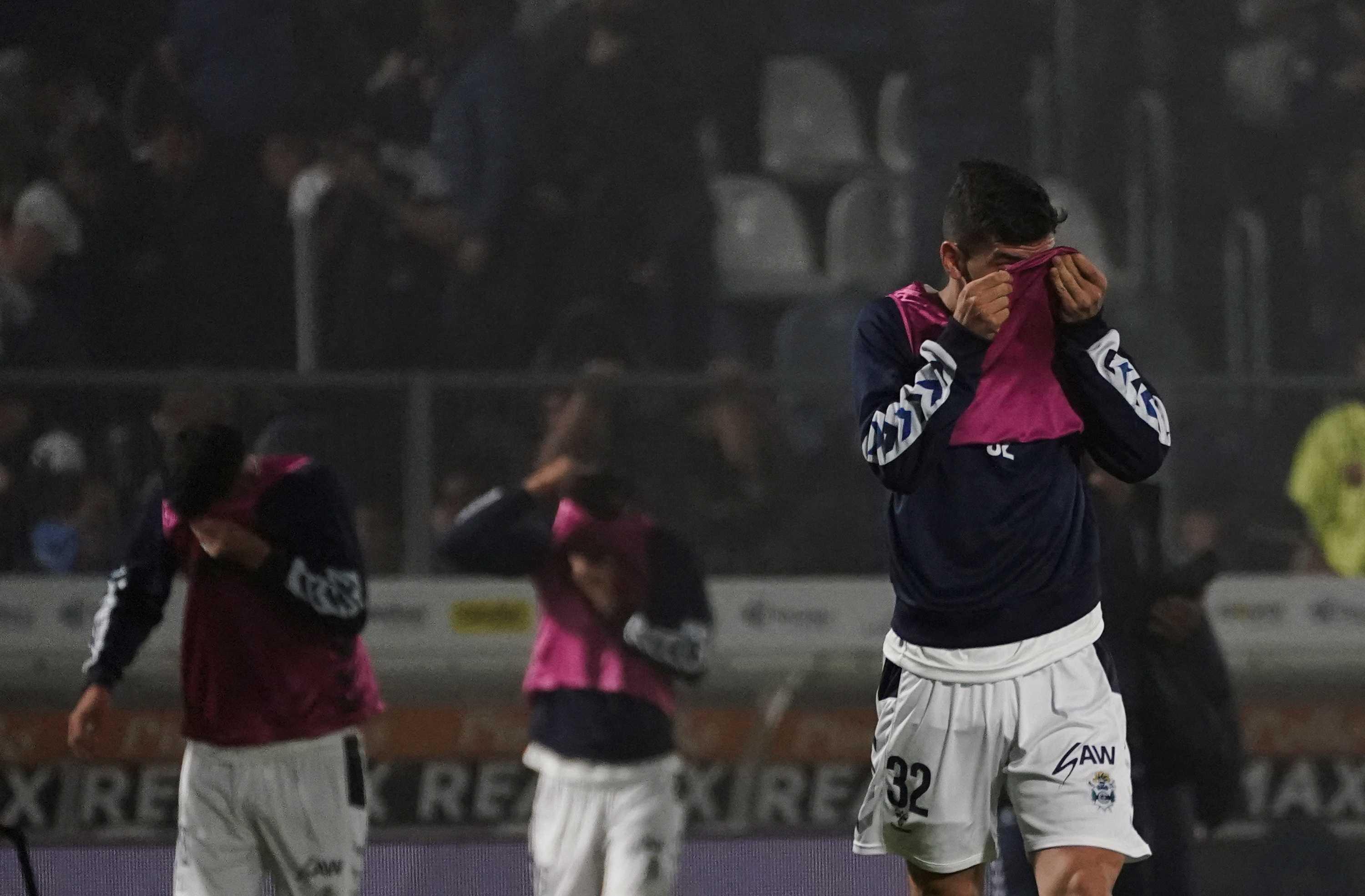 Football players protect themselves from tear gas during the match between Gimnasia y Esgrima La Plata and Boca Juniors in the Liga Profesional 2022, at Juan Carmelo Zerillo Stadium, in La Plata, Argentina October 6. Photo: Reuters