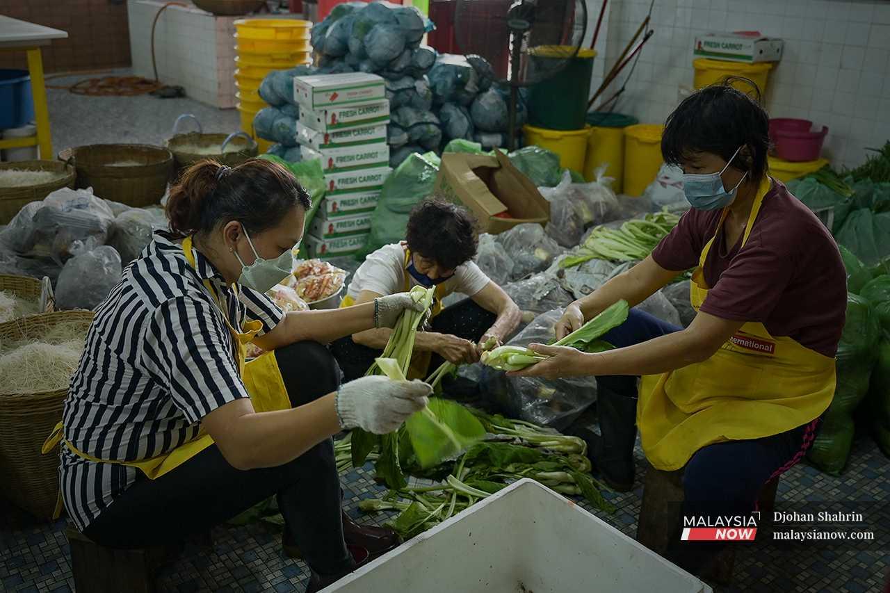 Pekerja tokong menyusun sayur-sayuran yang menjadi menu perayaan. Secara tradisi, penganut tidak memakan daging sepanjang perayaan berlangsung.

