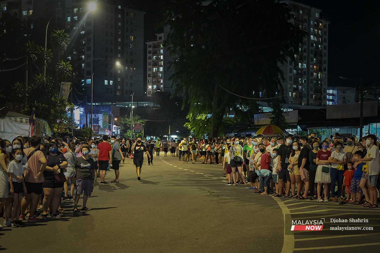 People line the road to await the arrival of the Nine Emperor Gods in the first celebration of the festival since the onset of the Covid-19 pandemic two years ago.