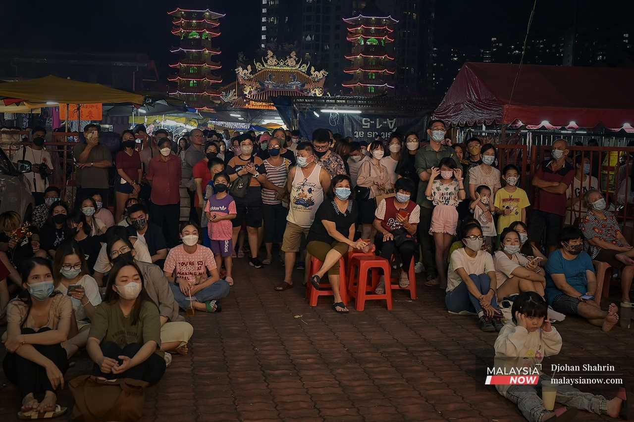 Crowds gather to watch the performance, which is held on an outdoors stage.