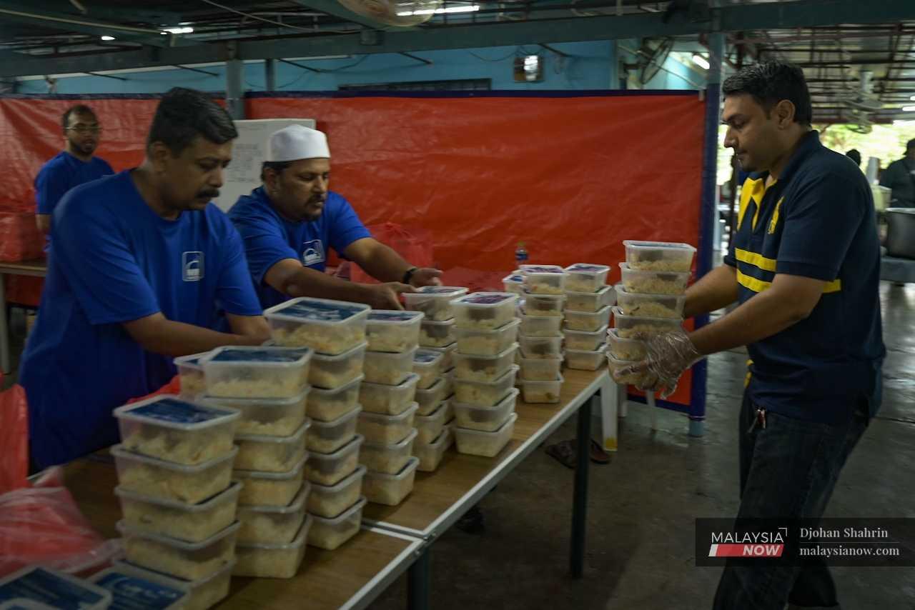 The containers of food are given to committee members who then distribute them throughout the Klang Valley.