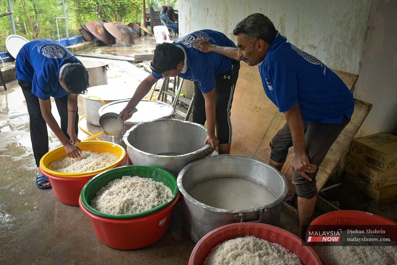 Di dapur, sukarelawan masih sibuk memasak nasi dalam periuk besar.


