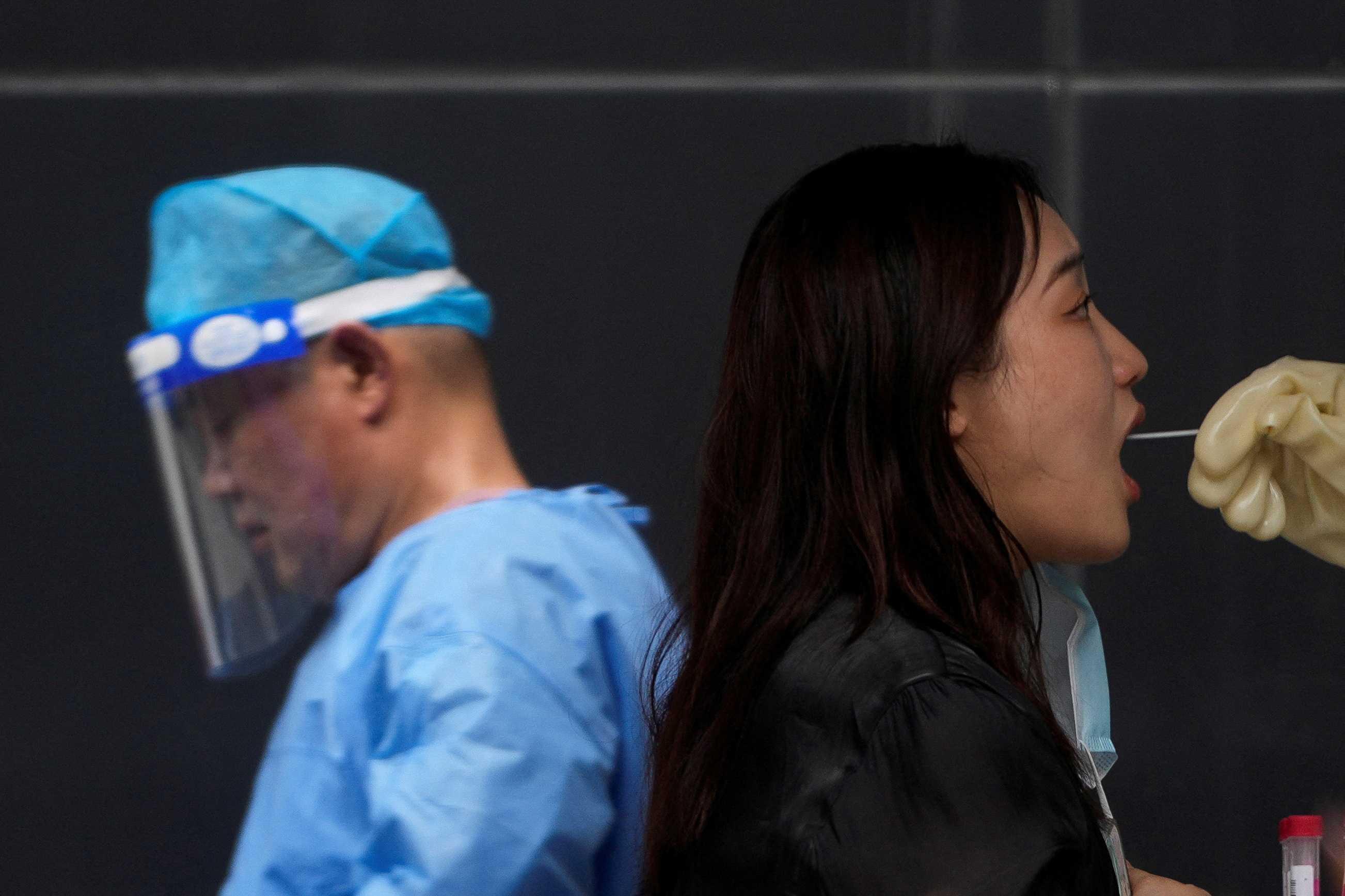 A woman gets tested for Covid-19 on a street, amid new lockdown measures in parts of the city to curb the Covid-19 outbreak in Shanghai, China July 11. Photo: Reuters