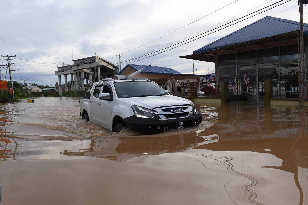 A vehicle fords the floodwaters in Jalan Ketiau Putatan following continuous heavy rain around Kota Kinabalu yesterday. Photo: Bernama