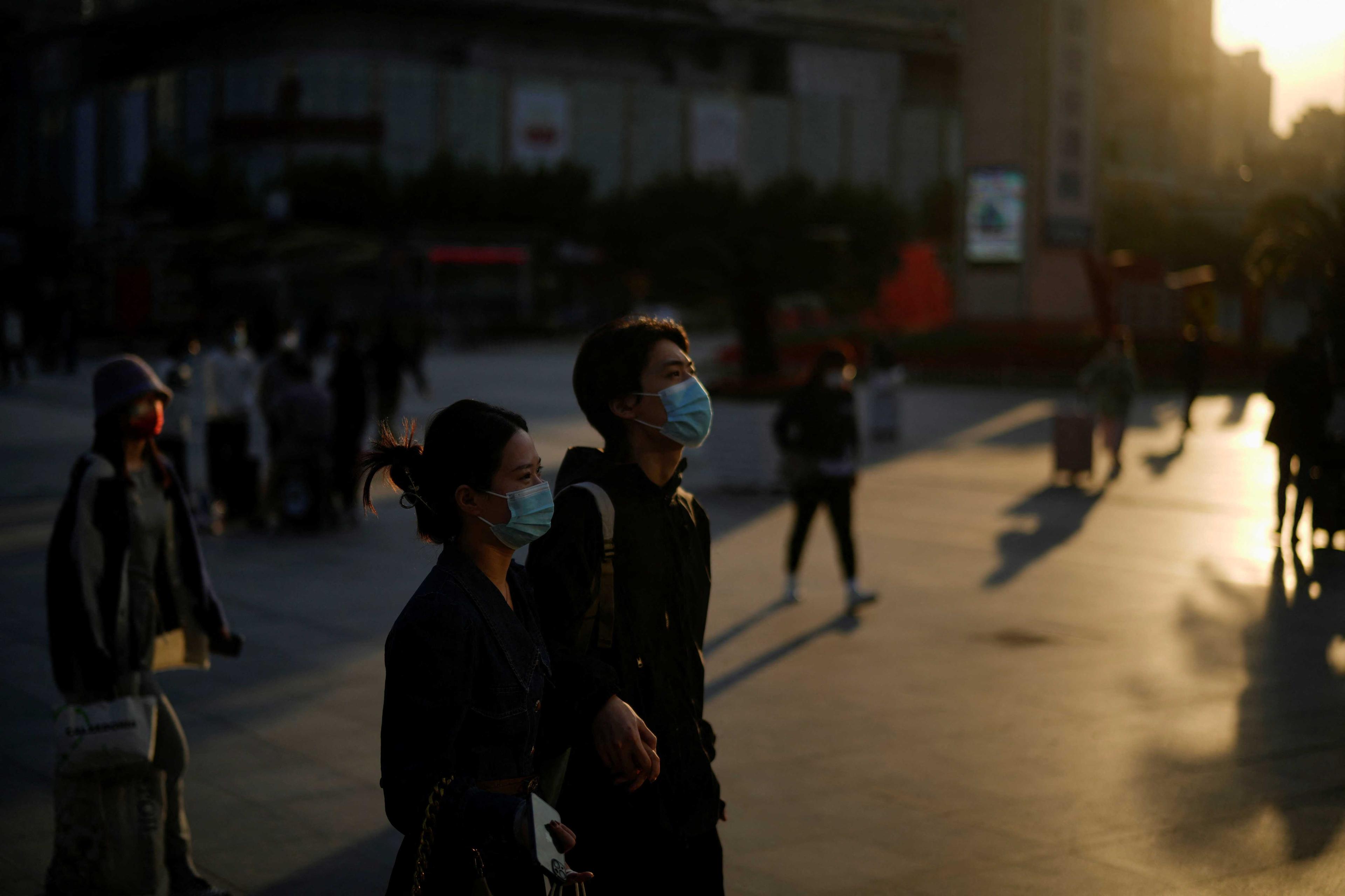People wearing protective face masks walk, following the Covid-19 outbreak, in Shanghai, China, Oct 10. Photo: Reuters