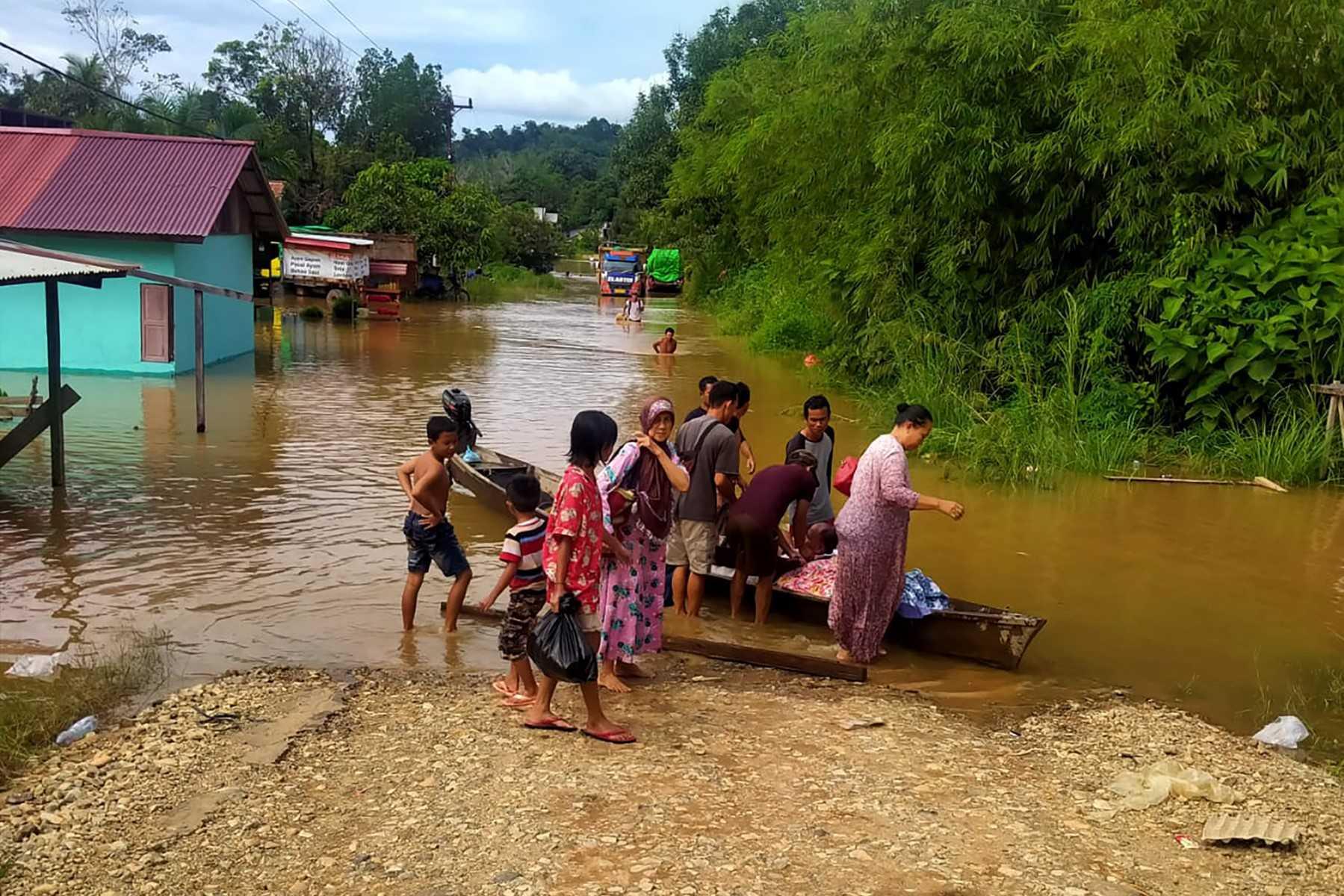 Penduduk Kapuas Hulu di Kalimantan Barat dibawa menggunakan sampan ketika banjir. Gambar: AFP