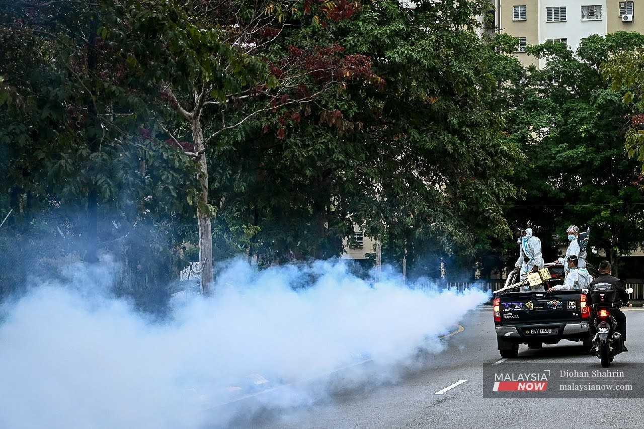 Volunteers conduct fogging activities to prevent the breeding of Aedes mosquitoes at a housing area in Kuala Lumpur. 