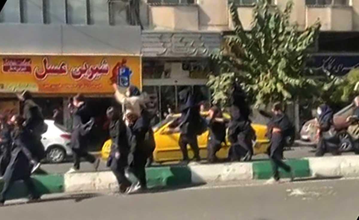 This grab taken from a UGC video made available on the ESN platform on Oct 12 shows Iranian students, some without headscarves, shouting 'death to the dictator' as they march in central Tehran. Photo: AFP