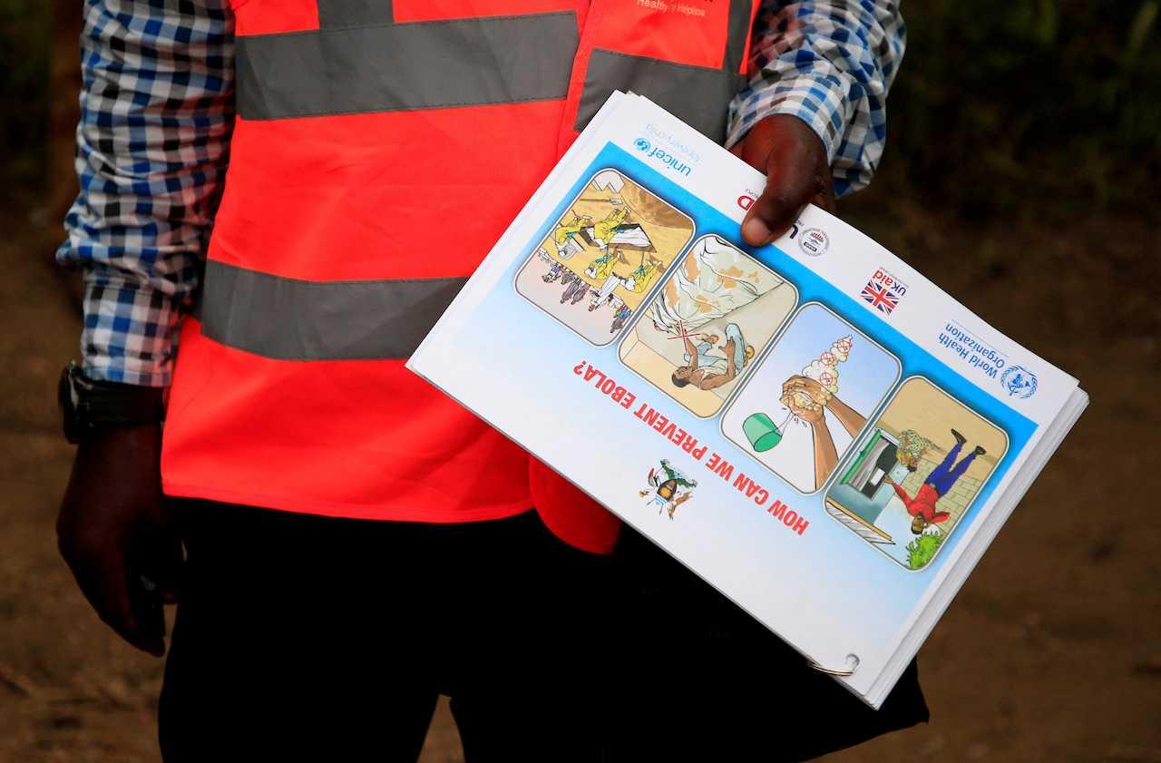 An Ugandan health worker shows an informational flyer on Ebola virus and how to prevent its spread to the community of Kirembo village, near the border with the Democratic Republic of Congo, in Kasese district, Uganda, June 15, 2019. Photo: Reuters