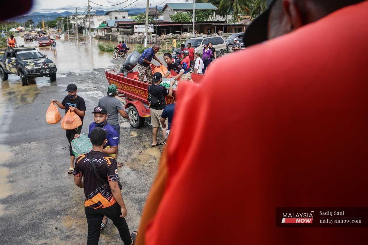Rescue teams distribute food and drinking water during flood relief efforts in Selangor after the floods that hit in December last year. 