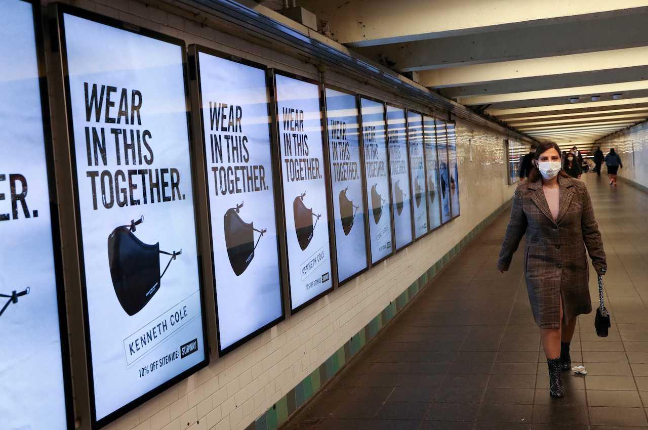 A subway rider passes ads for face masks at Times Square station in Manhattan, New York City, in the US, Nov 14, 2020. Photo: Reuters