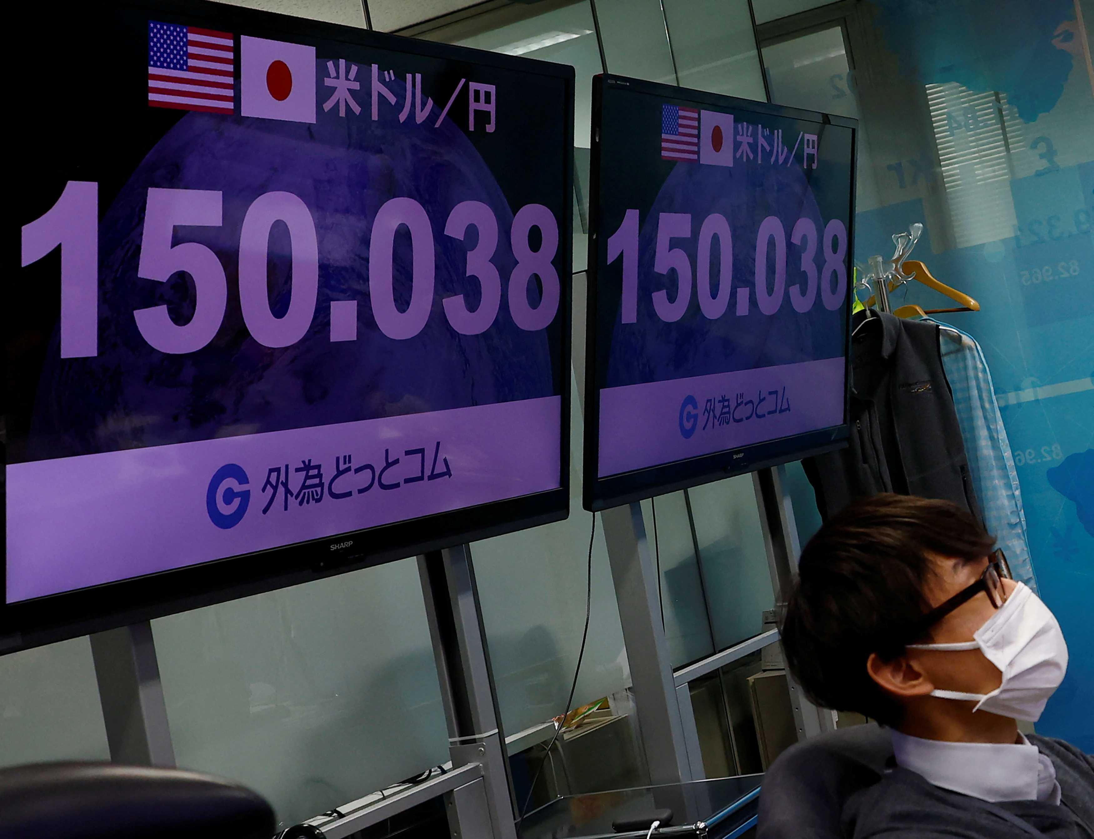 An employee of the foreign exchange trading company Gaitame.com watches the Japanese yen exchange rate against the US dollar at its dealing room in Tokyo, Japan, Oct 20. Photo: Reuters