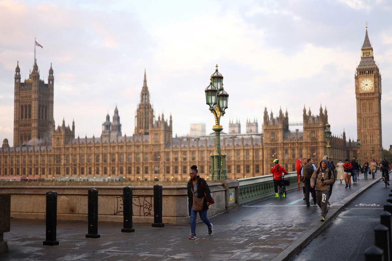 People walk outside the Houses of Parliament during sunrise in London, Britain, Oct 21. Photo: Reuters