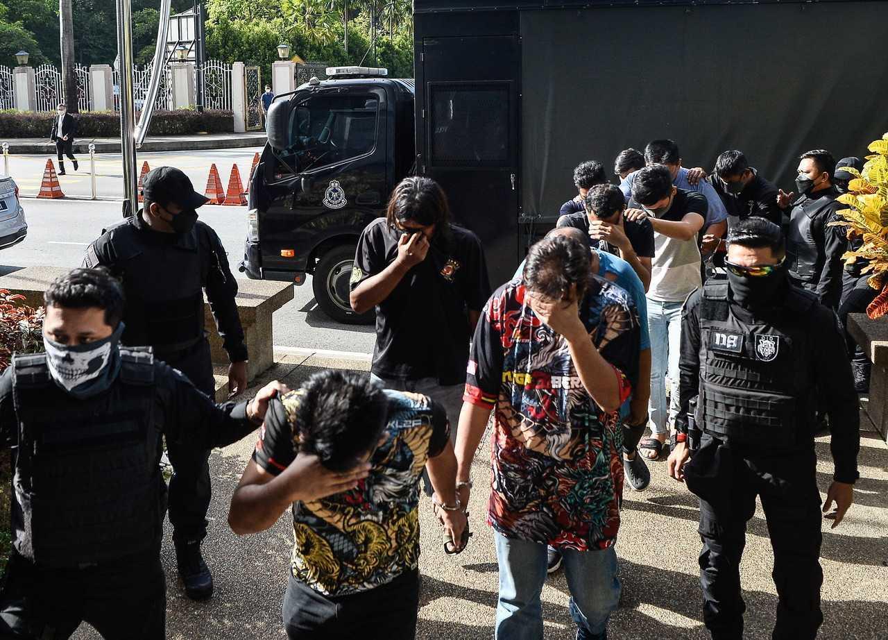 Eleven individuals accused of abducting a Palestinian man are escorted into the Kuala Lumpur Magistrate's Court on Oct 14. Photo: Bernama
