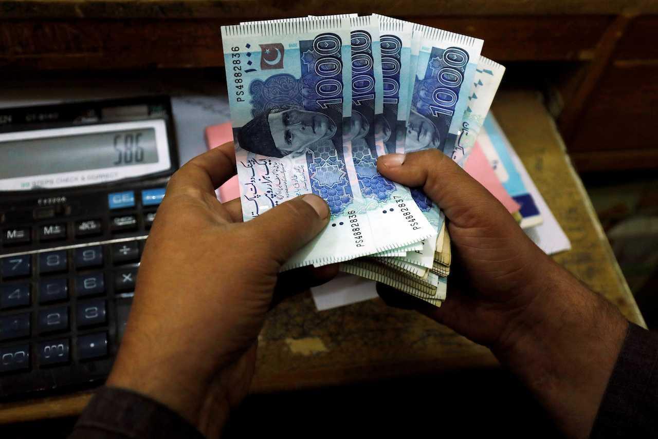 A trader counts Pakistani rupee notes at a currency exchange booth in Peshawar, Pakistan, Dec 3, 2018. Photo: Reuters