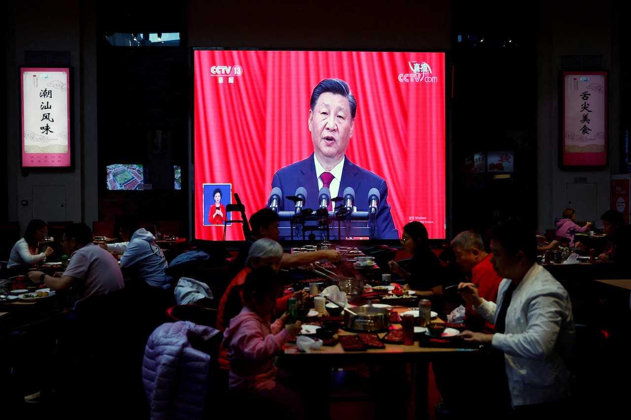 Diners eat in front of a screen showing live broadcast of Chinese President Xi Jinping's speech at the opening ceremony of the 20th National Congress of the Communist Party of China, in a restaurant in Beijing, China, Oct 16. Photo: Reuters