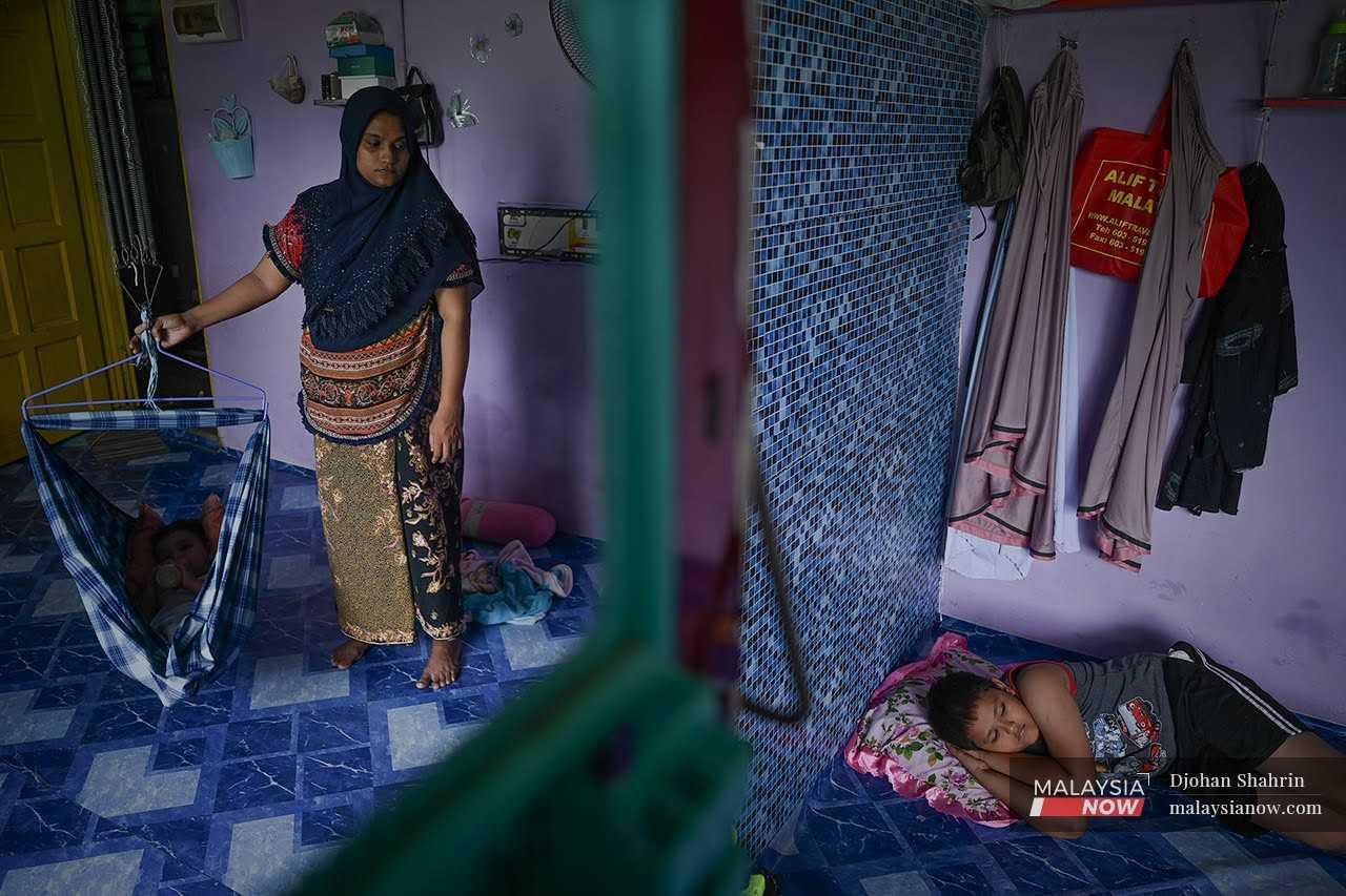 Seorang wanita Rohingya menjaga anak-anaknya di rumah mereka di Selayang, Kuala Lumpur.