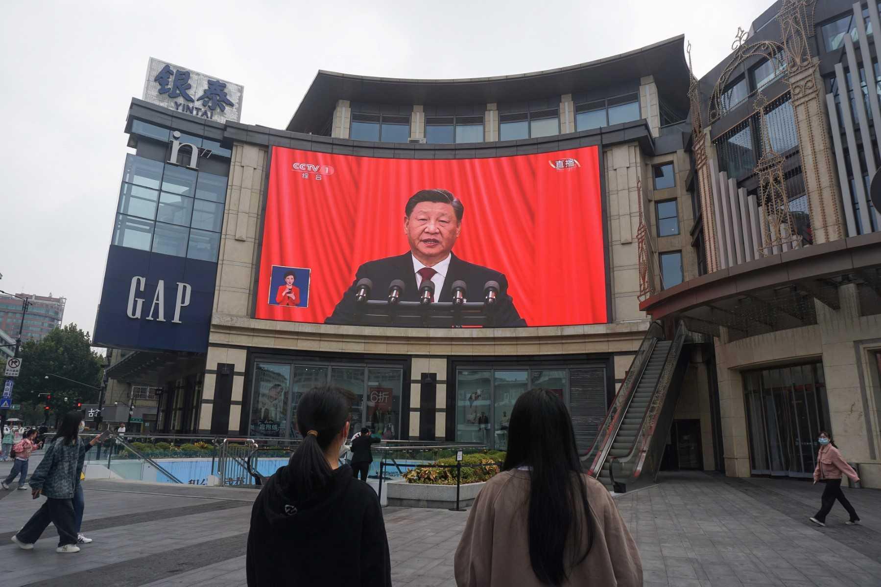 People watch an outdoor screen showing the live speech of Chinese President Xi Jinping during the opening session of the 20th Chinese Communist Party Congress in Hangzhou, in China’s eastern Zhejiang province on Oct 16. Photo: AFP