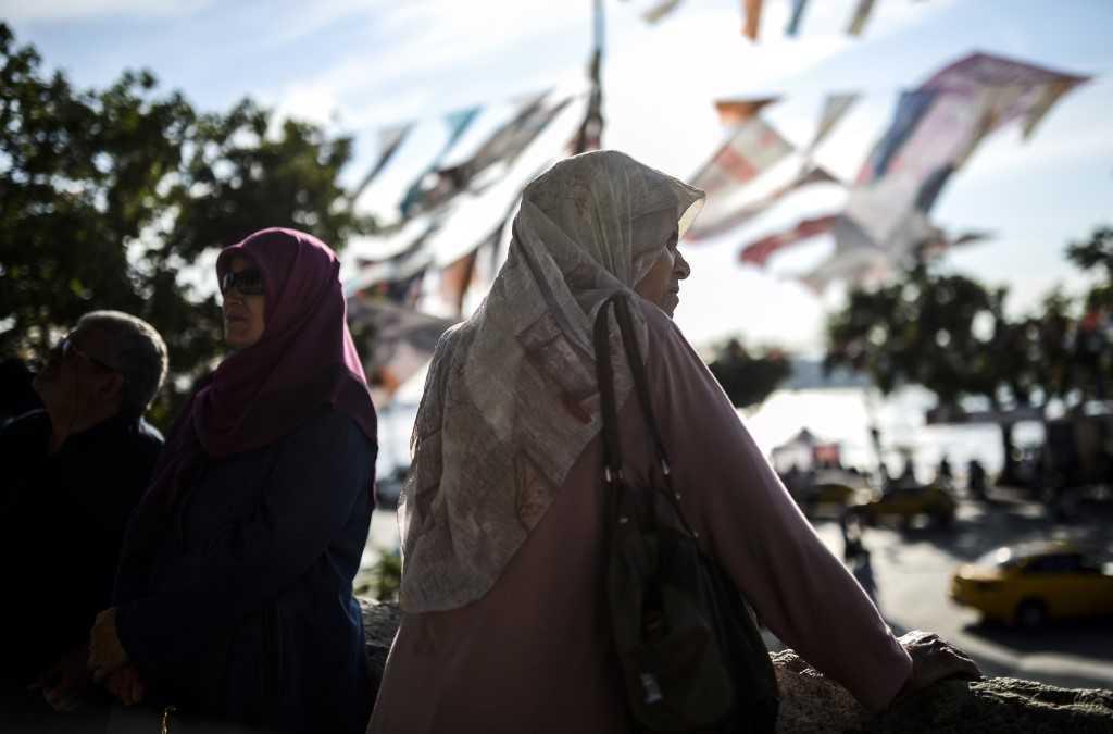 A woman wearing a headscarf stands under election flags in this file picture taken on June 4, 2015, at Uskudar, in Istanbul. Photo: AFP