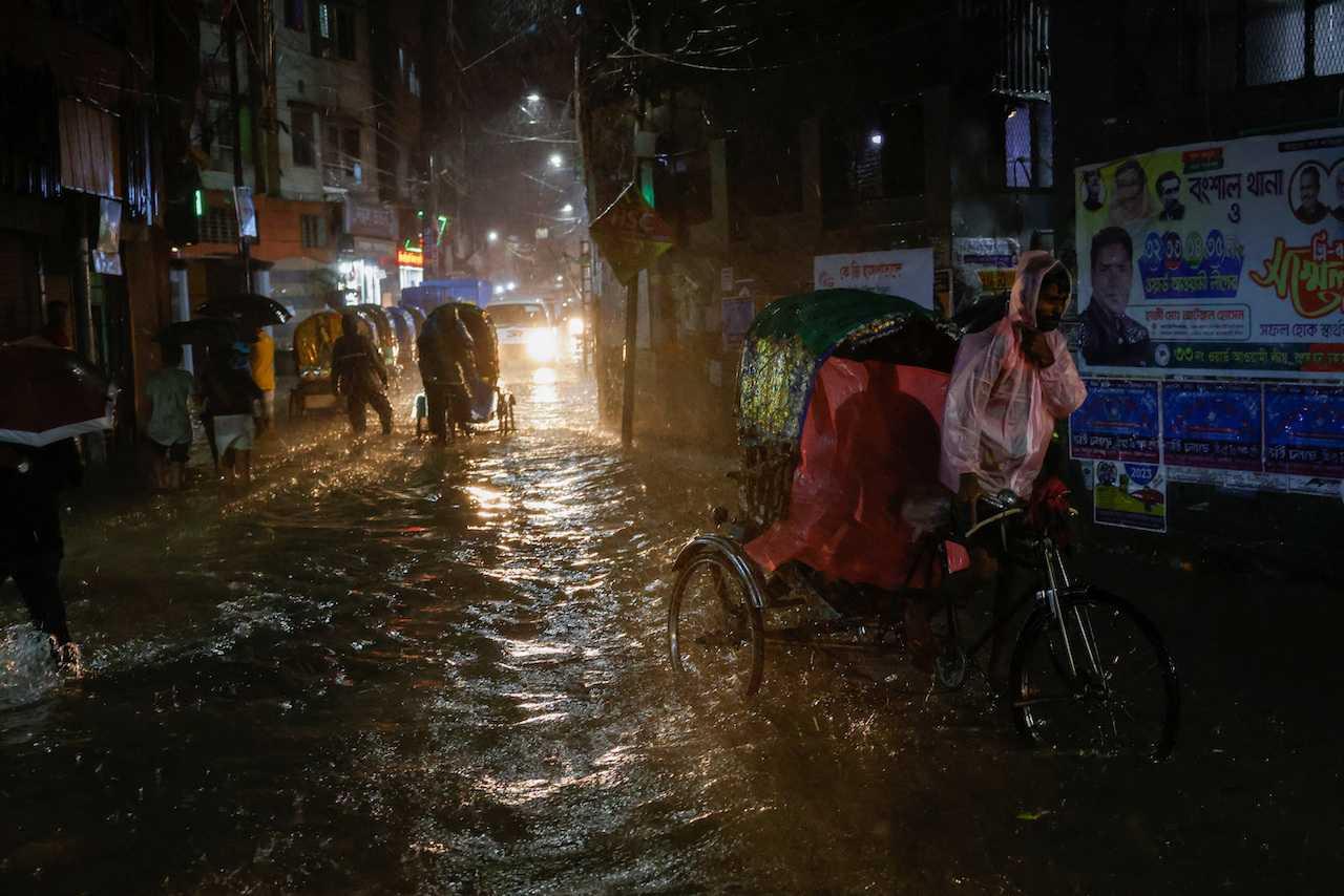 Rickshaws move through a flooded street, amid continuous rain before the Cyclone Sitrang hits the country in Dhaka, Bangladesh, Oct 24. Photo: Reuters
