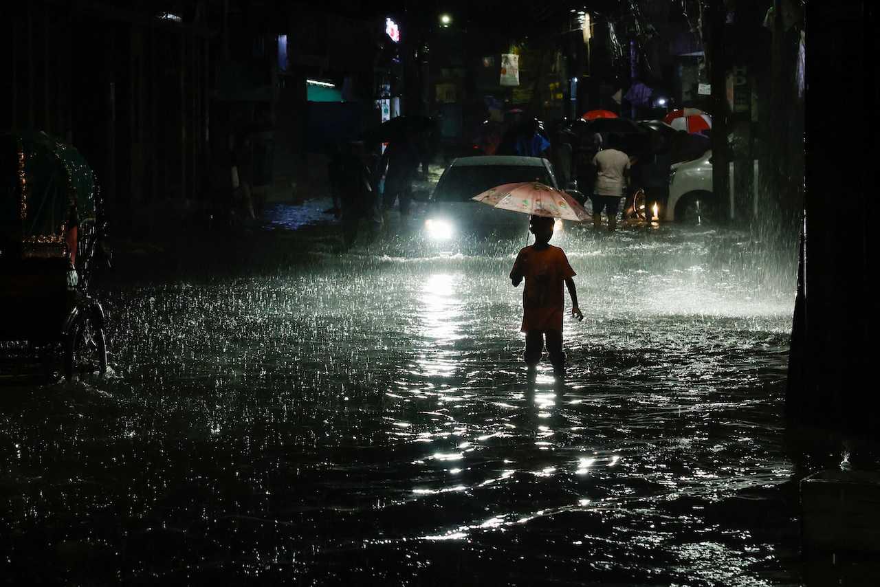 A boy wades through water as streets are flooded due to continuous rain, before the Cyclone Sitrang hits the country in Dhaka, Bangladesh, Oct 24. Photo: Reuters