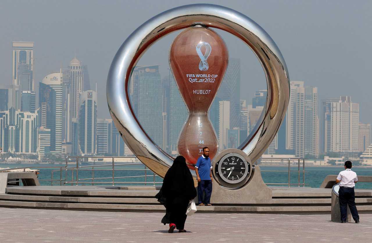 Members of the public pose for a photo next to a huge structure put up ahead of the Qatar World Cup on Nov 20, in this picture taken on Oct 26. Photo: Reuters