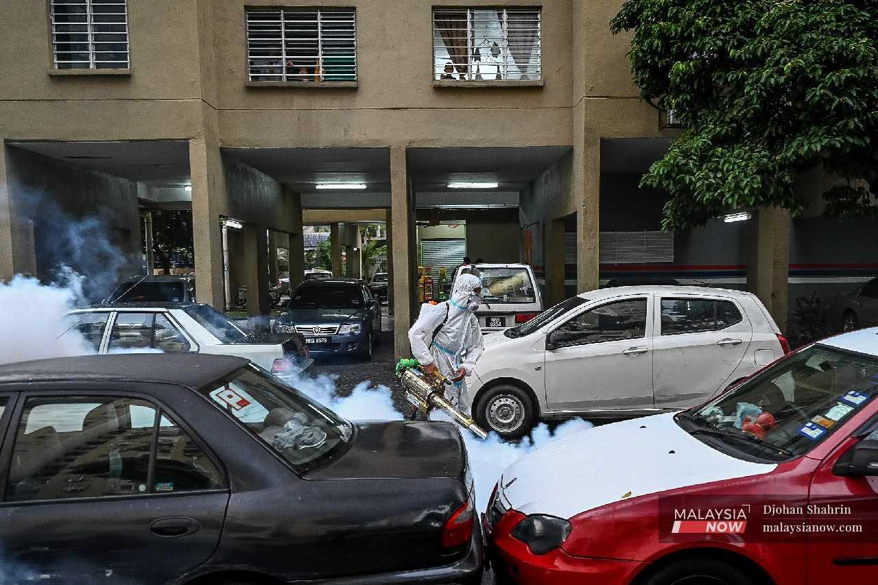 Volunteers conduct fogging activities to prevent the breeding of Aedes mosquitoes around the Pudu Ulu low-cost flats in Kuala Lumpur, in this November 2020 file photo.