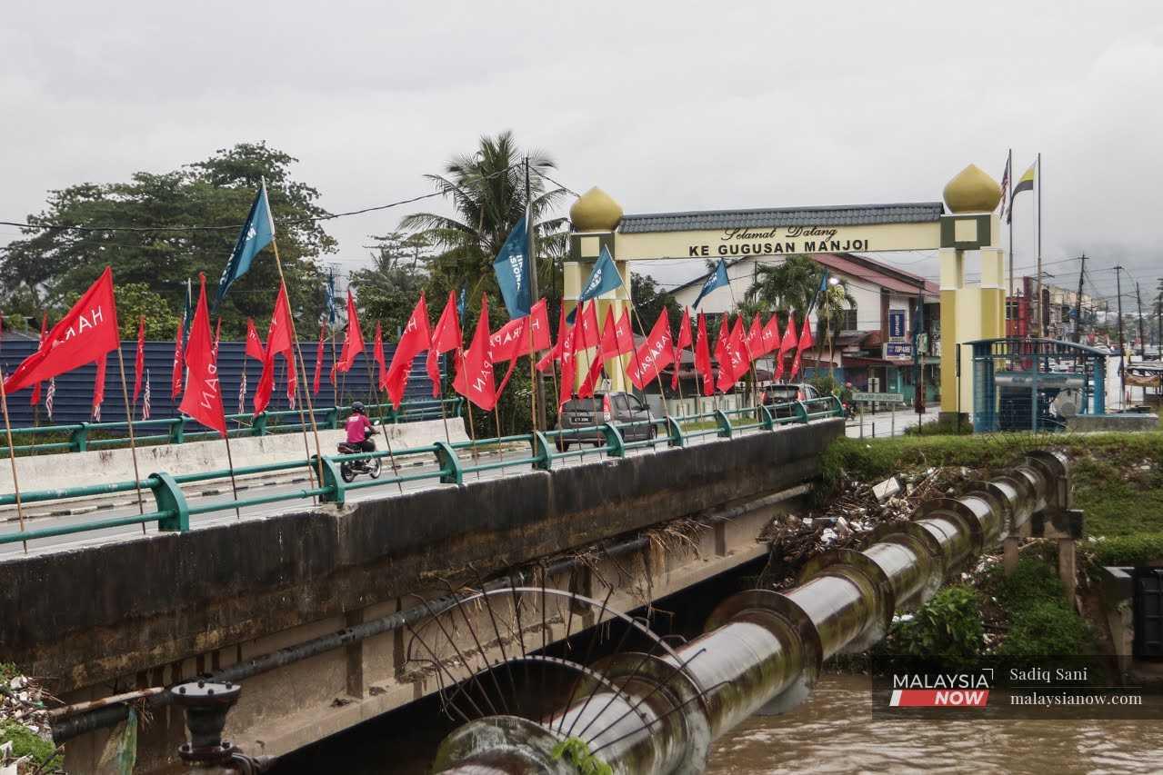 Kenderaan menyeberang jambatan yang dipenuhi bendera parti politik ketika negara bakal mengundi pada pilihan raya 19 November depan.