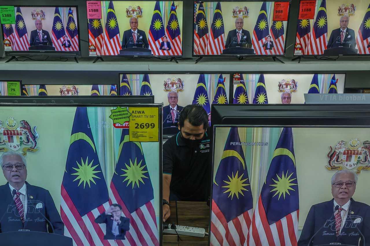 Prime Minister Ismail Sabri Yaakob is seen on television screens at an electronics store as he announces the dissolution of Parliament on Oct 10. Photo: Bernama
