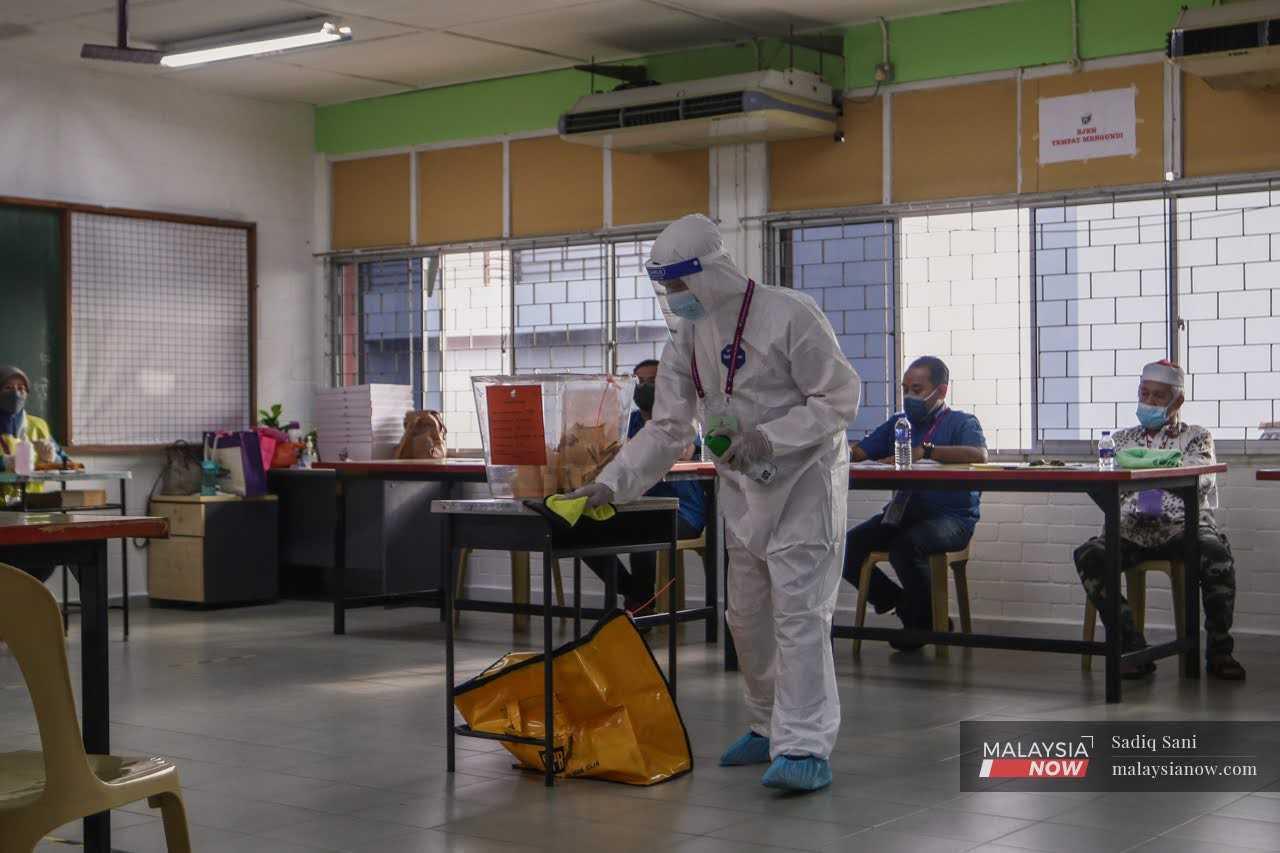 An Election Commission worker in full personal protective equipment sanitises a ballot box at a polling centre in Johor at the recent state election.