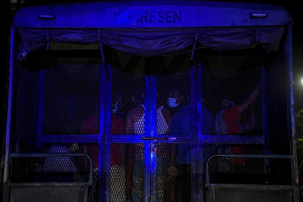 Pekerja asing diangkut ke dalam trak untuk dibawa ke depoh tahanan imigresen di Semenyih selepas serbuan di Dengkil tahun lalu. Gambar: Bernama