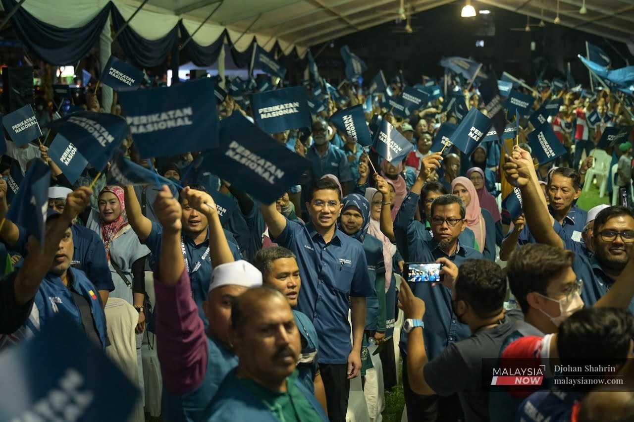 Gombak incumbent Mohamed Azmin Ali waves Perikatan Nasional flags with participants at an event in Selangor last night. 
