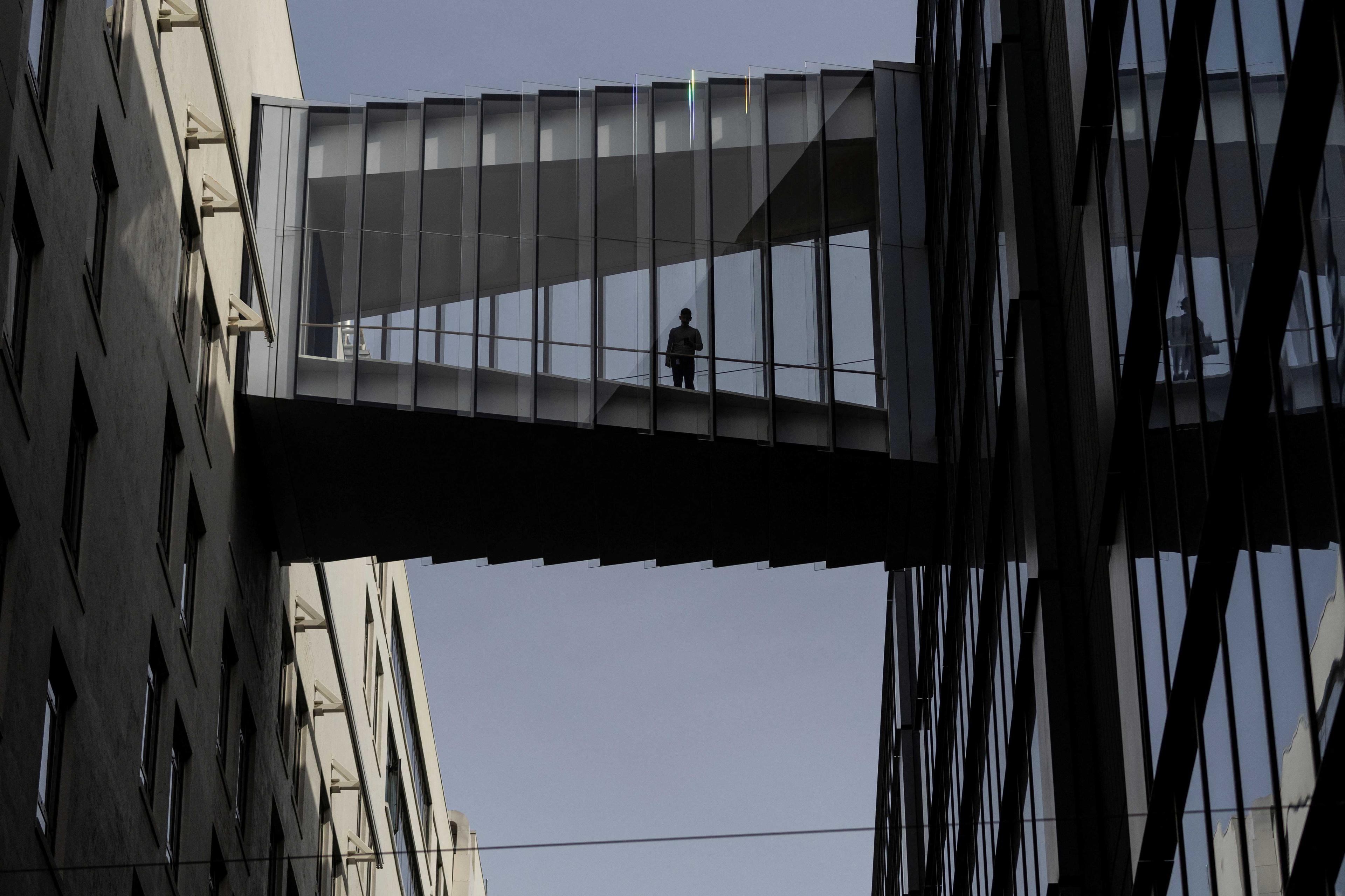 A man stands on a glass bridge connecting both Twitter corporate headquarters buildings in San Francisco, California, US Oct 28. Photo: Reuters