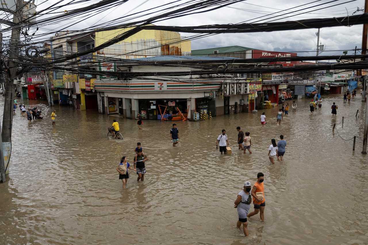 People wade through flooded streets following heavy rain from Tropical Storm Nalgae, in Imus, Cavite province, Philippines, Oct 30. Photo: Reuters