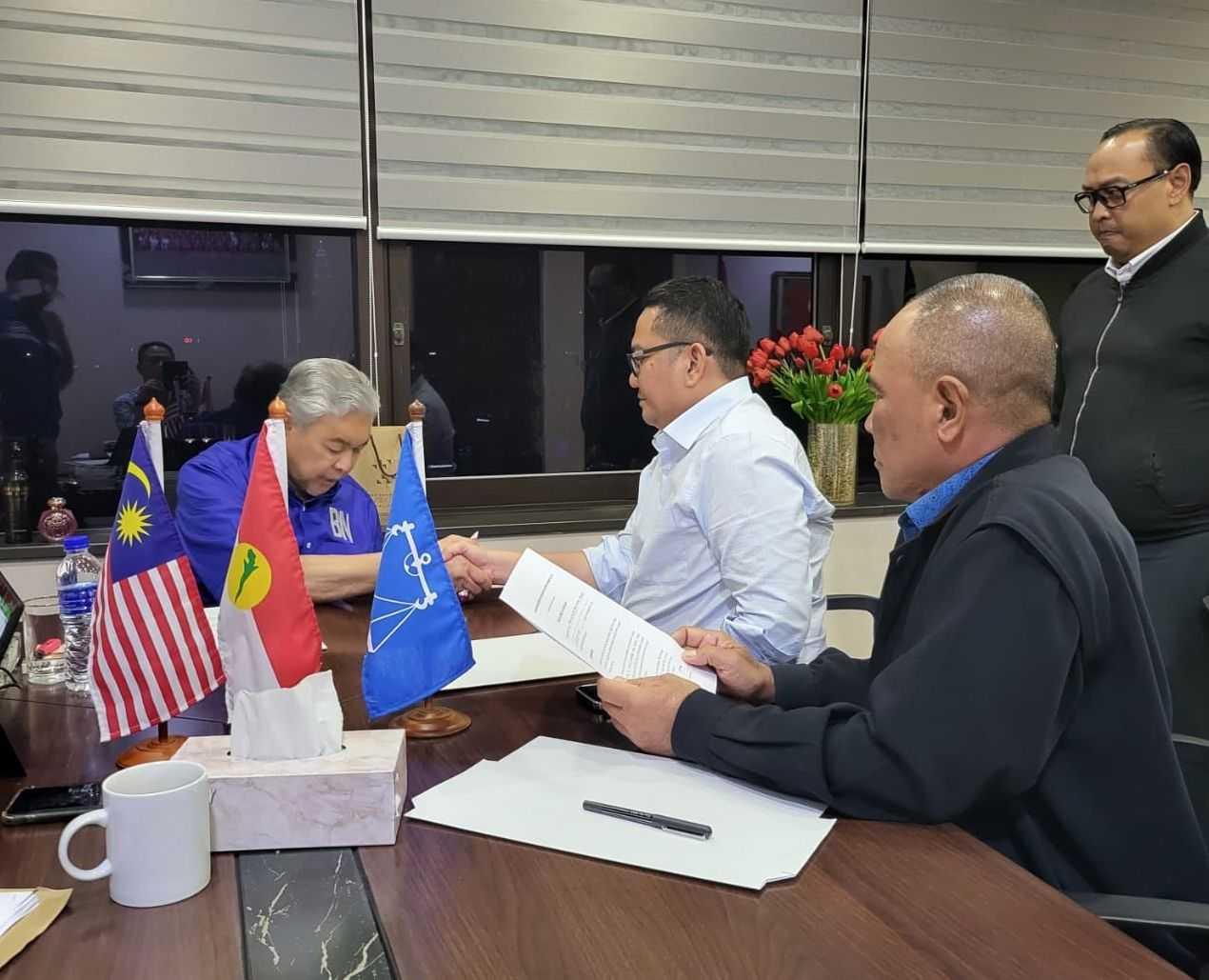 Anuar Basiran, the deputy Umno chief in Sepang, shakes hands with party president Ahmad Zahid Hamidi after signing a statutory declaration in this picture making the rounds on social media.