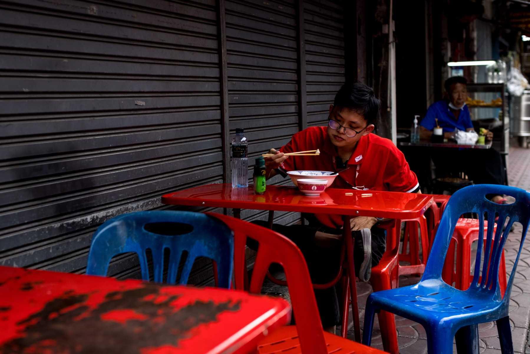 A person eats a bowl of food at a street stall in Bangkok on Nov 9, 2021. The cybercrime rings first emerged in Cambodia, but have since moved into other countries in the region and are targeting more tech-savvy workers, including from India and Malaysia. Photo: AFP