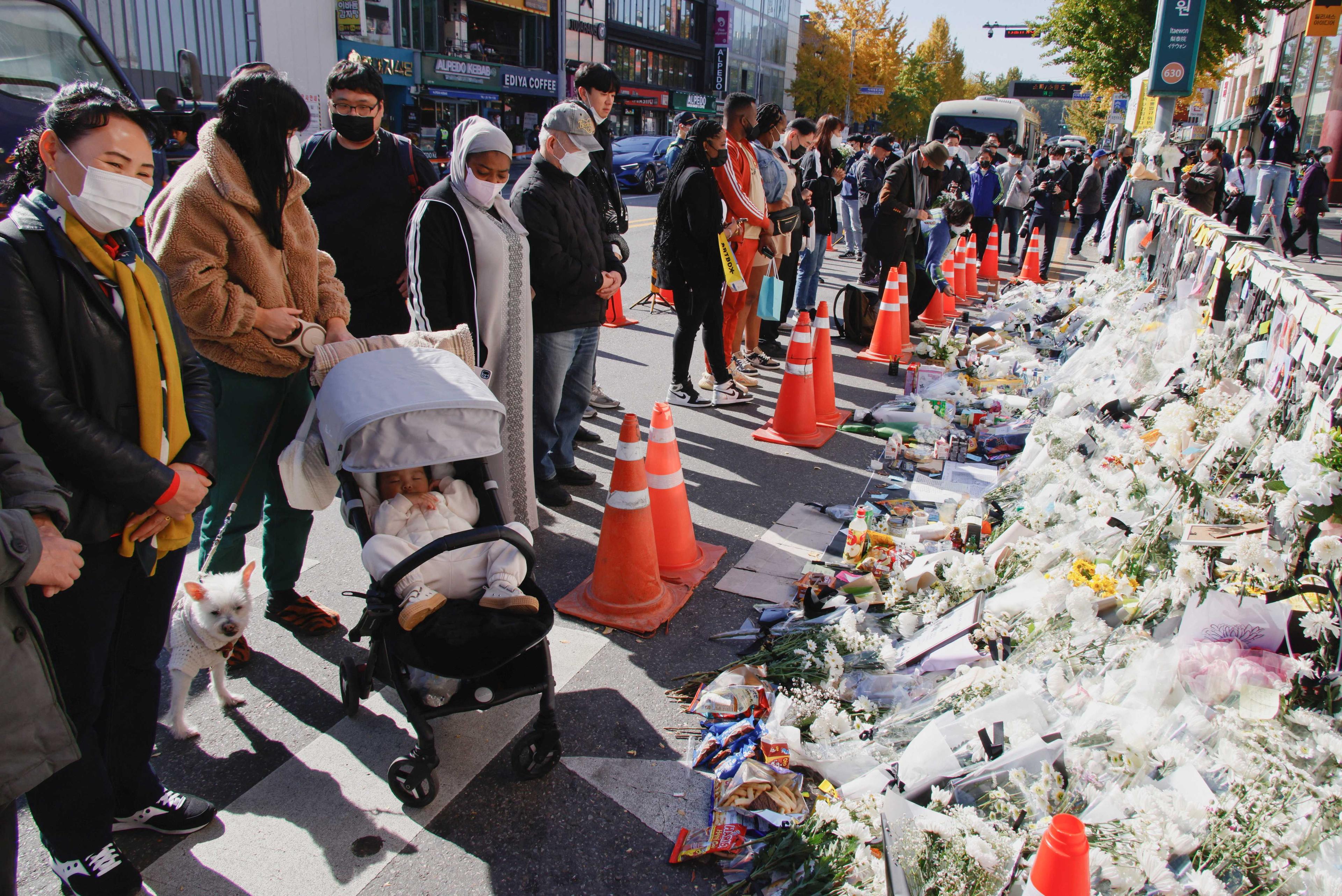 People mourn near floral tributes following a crowd crush that happened during Halloween festivities, in Seoul, South Korea, Nov 2. Photo: Reuters