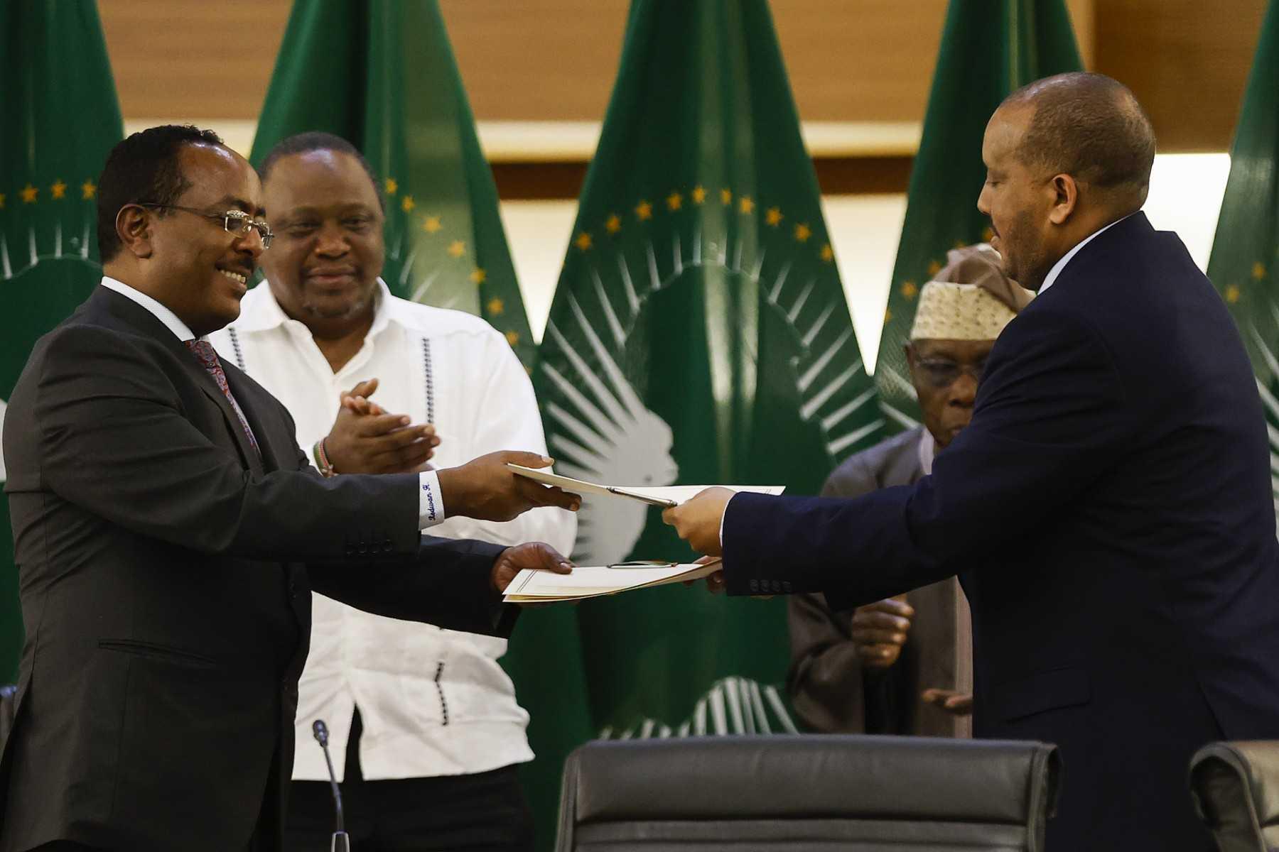 Representatives of the Ethiopian government and the Tigray People's Liberation Front, exchange documents after signing a peace agreement between the two parties during a press conference in Pretoria on Nov 2. Photo: AFP