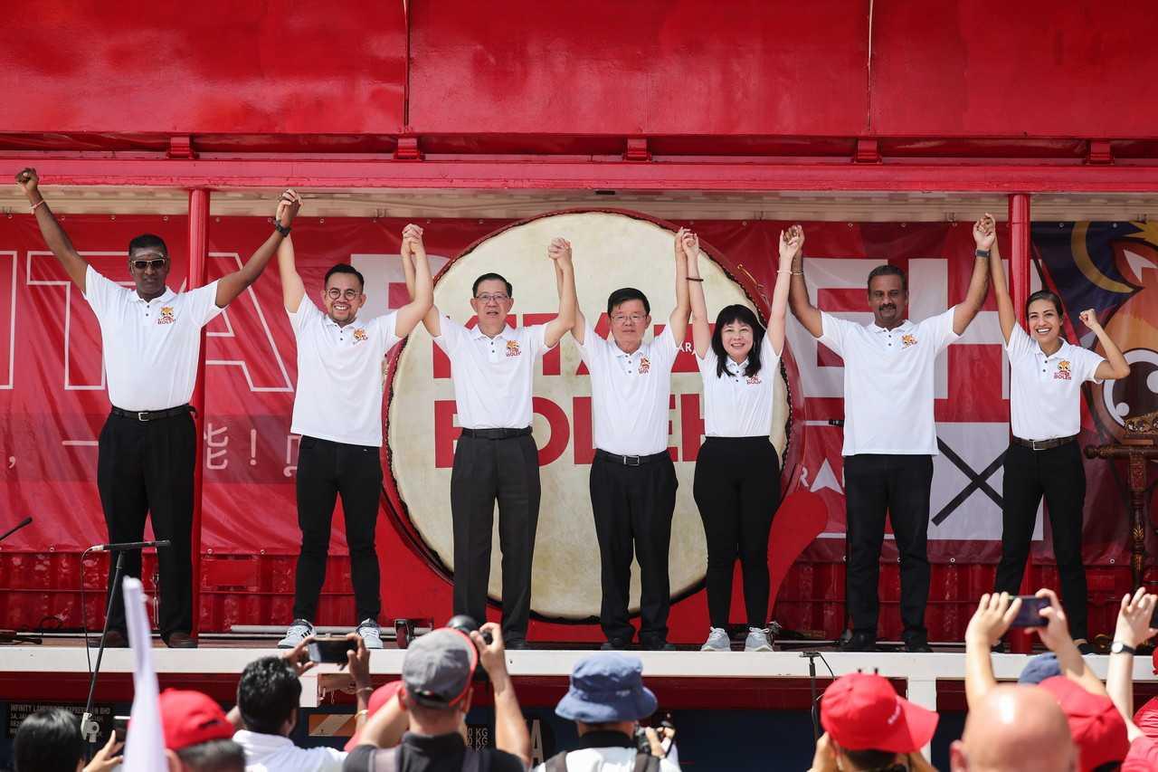 Pengerusi DAP Lim Guan ENg mengangkat tangan di pentas bersama calon lain termasuk adiknya, Lim Hui Ying (tiga dari kanan) di pelancaran jentera Pakatan Harapan di George Town, Pulau Pinang pada 30 Oktober. Gambar: Bernama